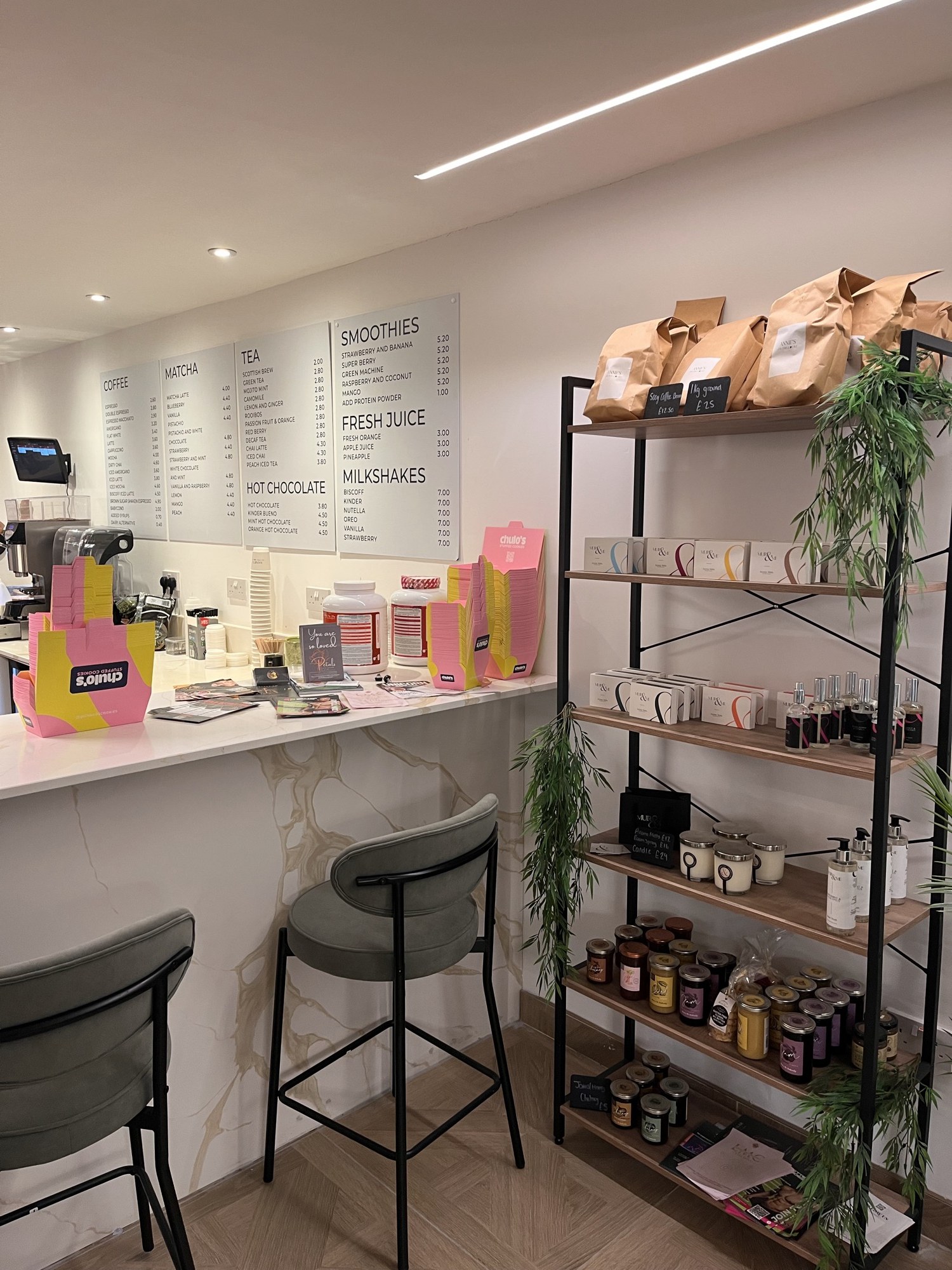 The café retail area with coffee, candles and a drinks board
