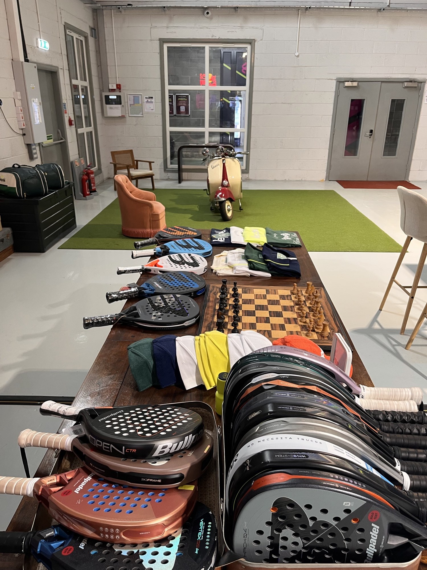 A pro-shop wall of rackets, apparel and a chessboard