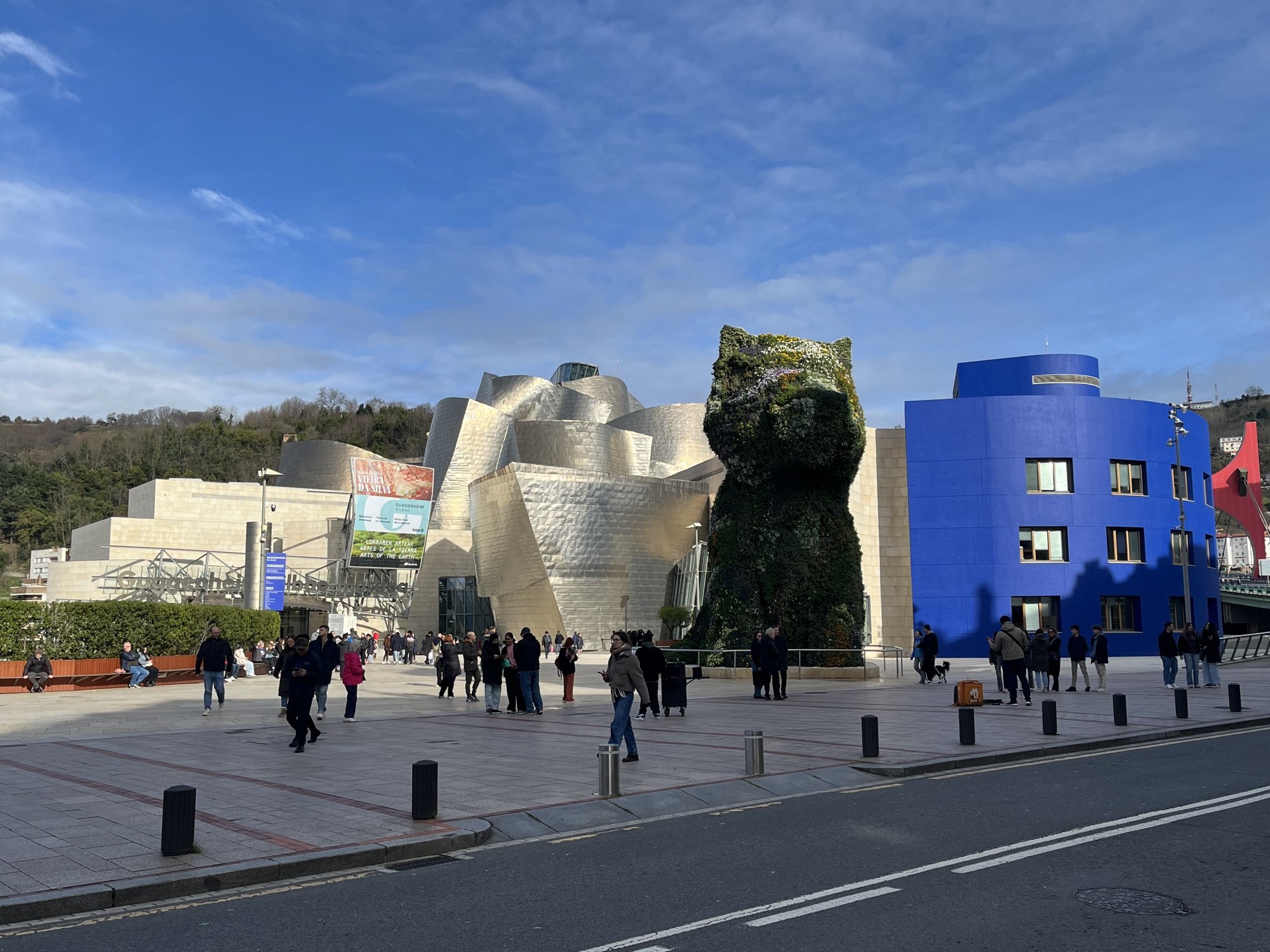 The Guggenheim plaza with the museum, Jeff Koons' flower Puppy and a blue building