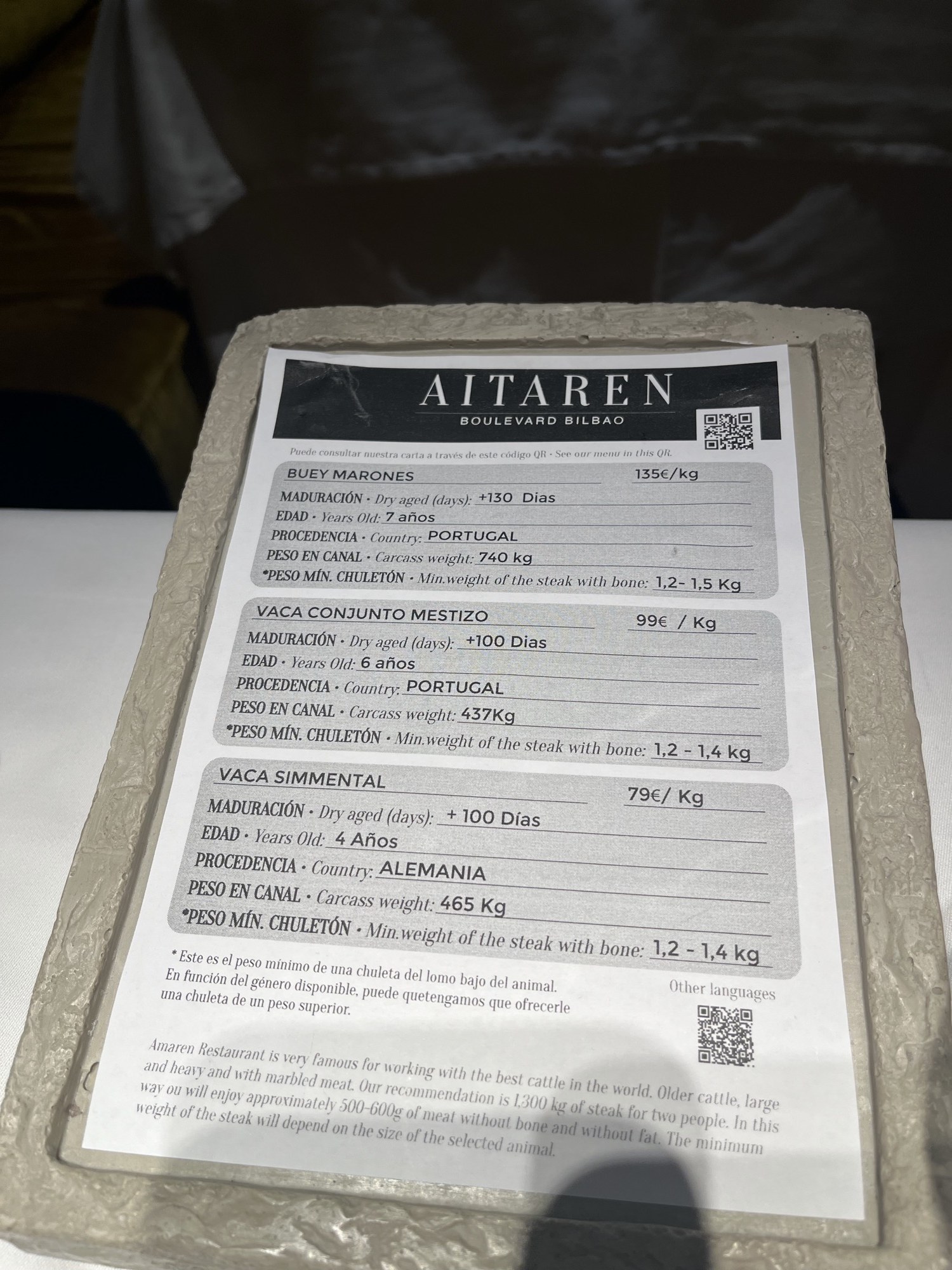 A stone menu card headed Aitaren Boulevard Bilbao listing beef breeds, ages and prices