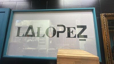 The stencilled LALOPEZ name on glass, the kitchen behind it