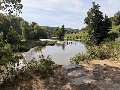 Bathers on the stone slabs at Warleigh Weir on the River Avon